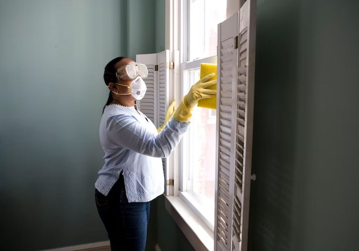 женщина моет окно