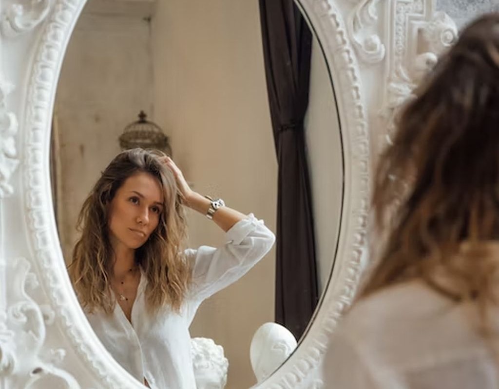 женщина смотрится в зеркало