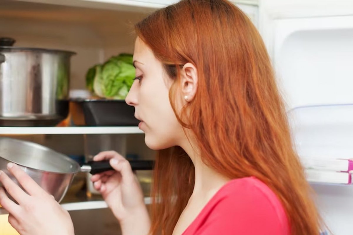 девушка проверяет продукты в холодильнике