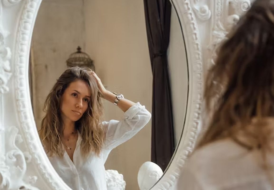 женщина смотрит в зеркало