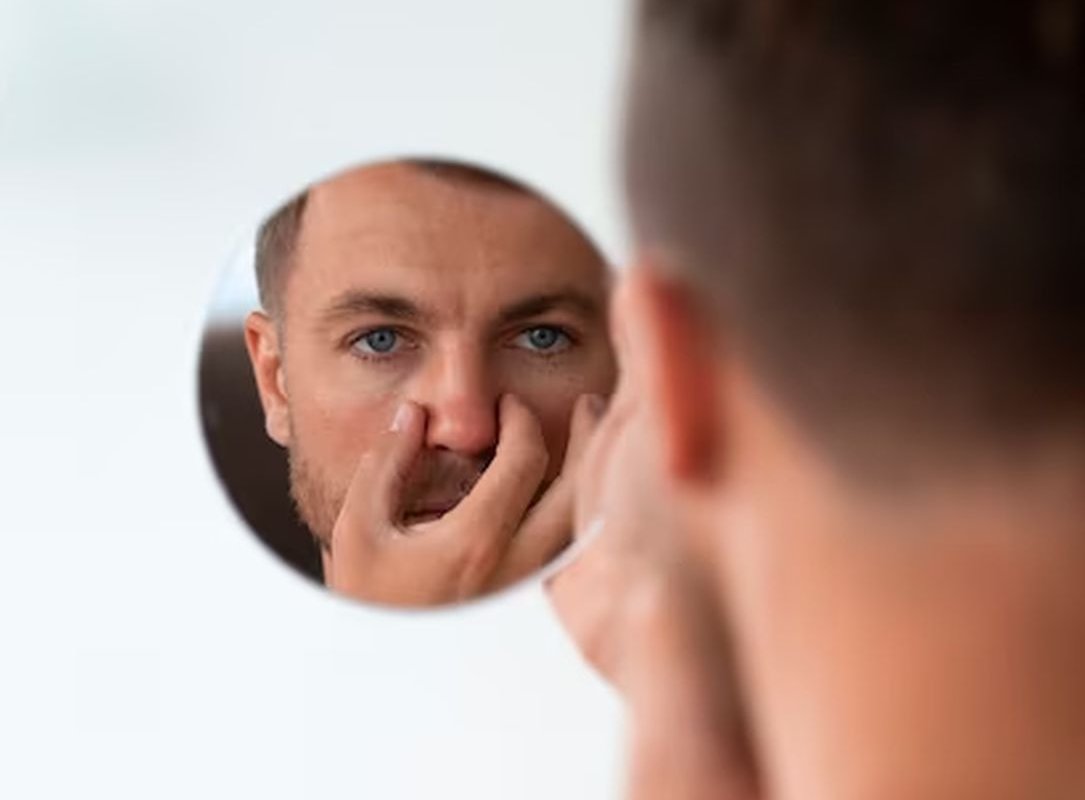 мужчина смотрится в зеркало