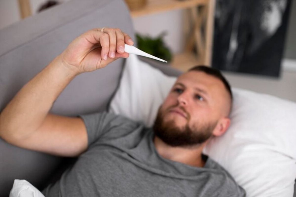 мужчина измеряет температуру