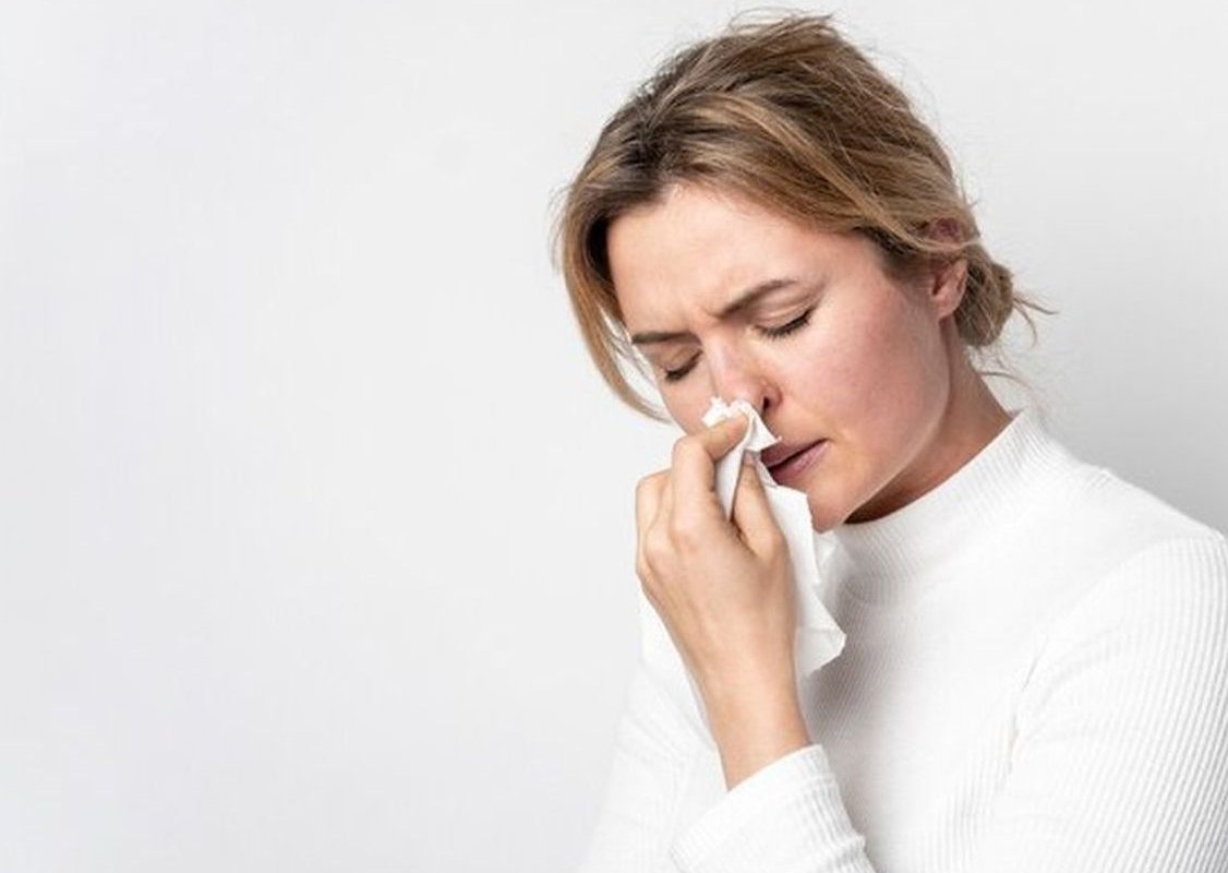 женщина держит платок у носа
