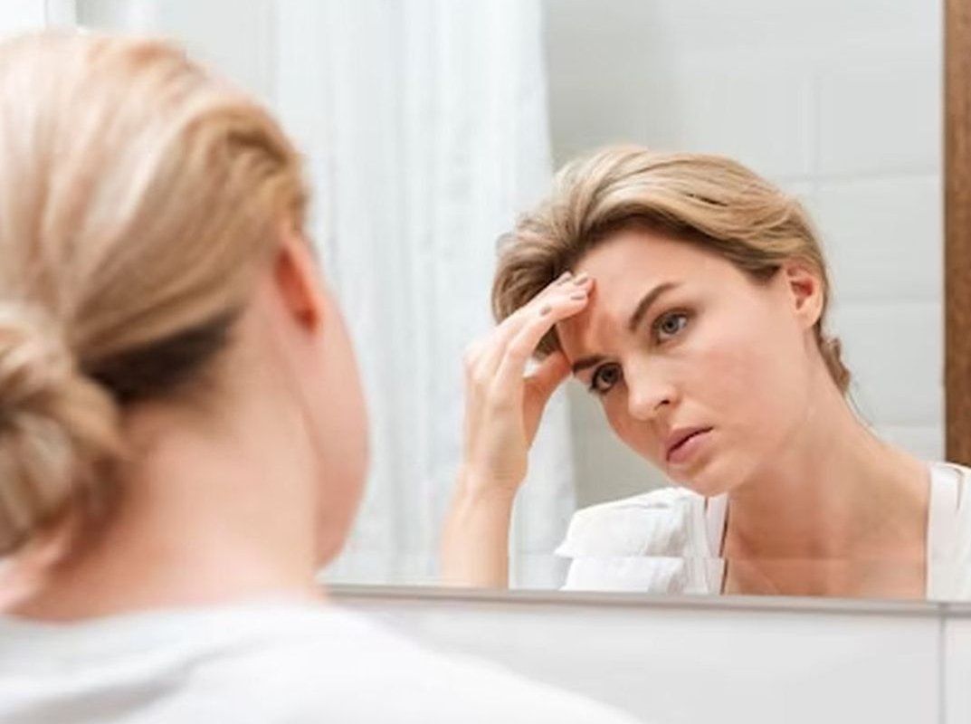 женщина смотрит в зеркало