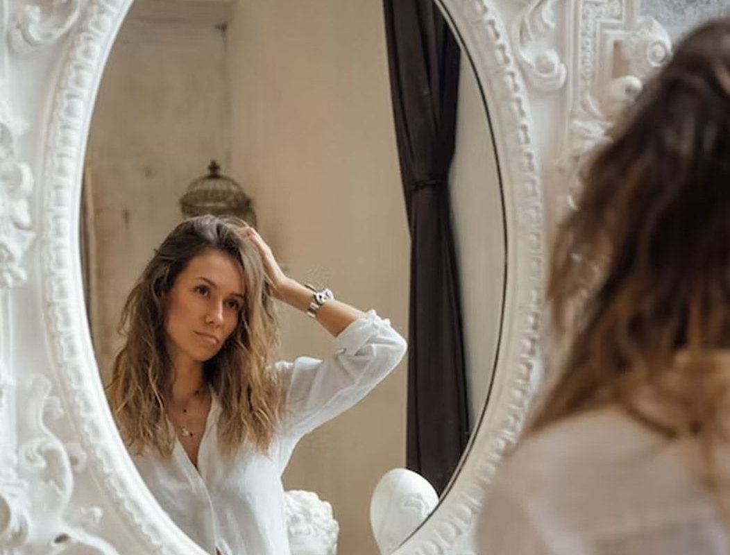 женщина смотрит в зеркало