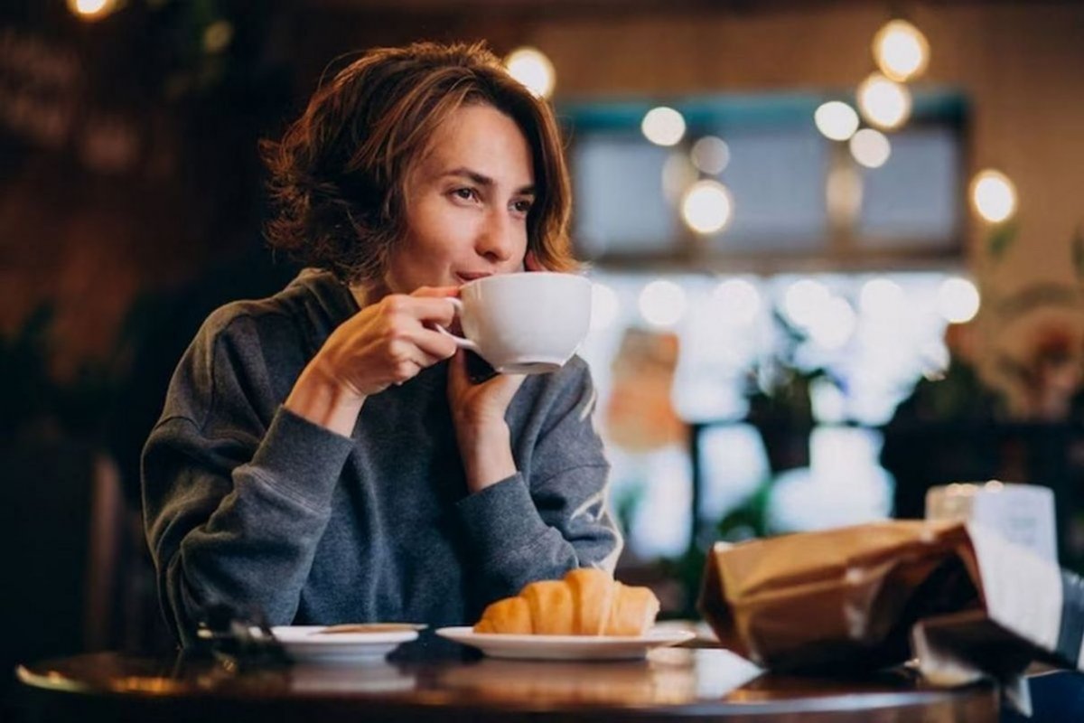 женщина с чашкой кофе за столом
