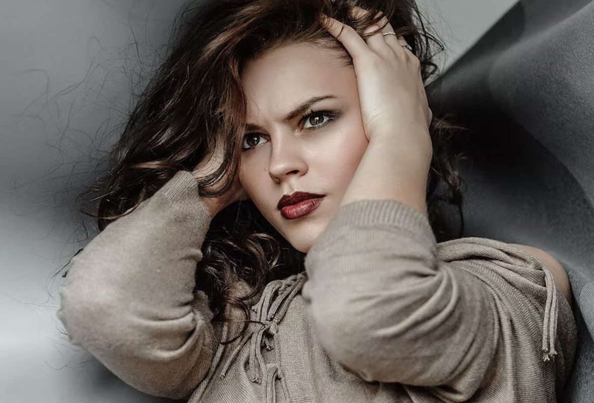 молодая женщина держится за голову