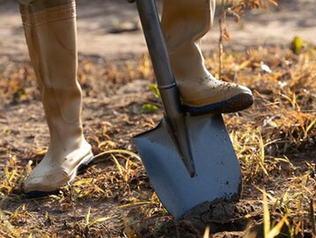 человек копает землю лопатой