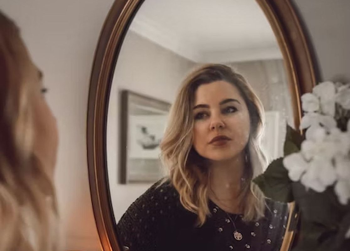 девушка смотрит на своей отражение